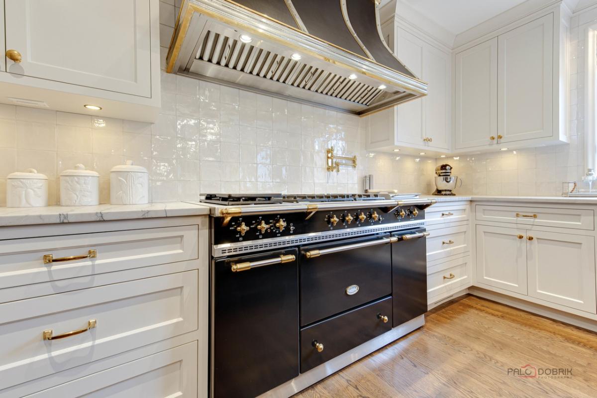 Kitchen with a stove, wood flooring and custom cabinets.