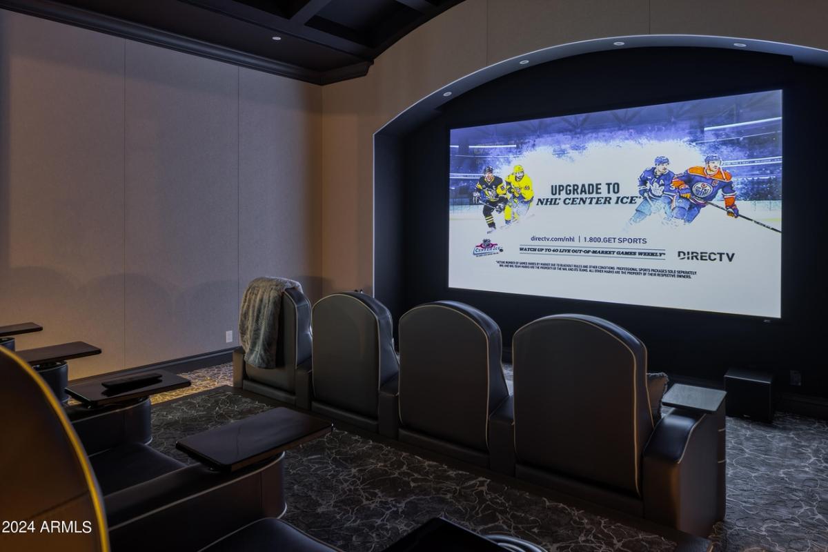 Home theater with a large screen and chairs.