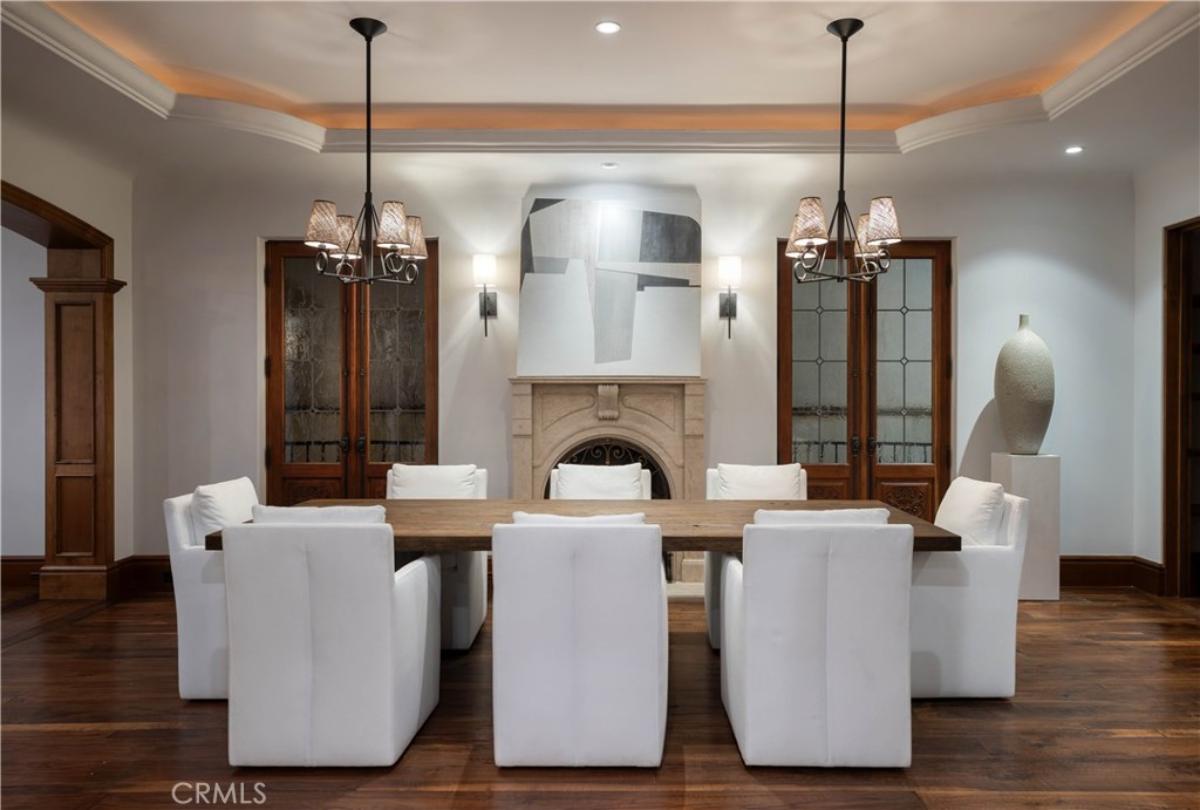 Dining room with a large table, chairs and a wood flooring.