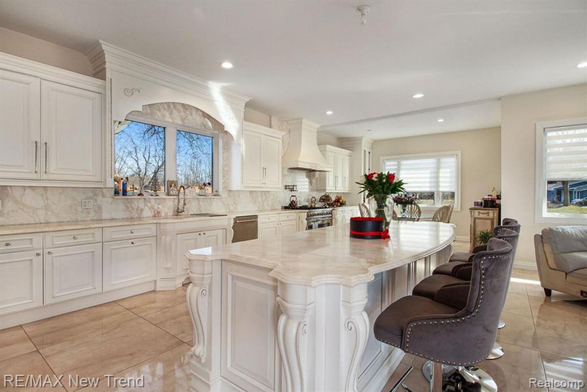 Kitchen with a large island, custom lights and custom cabinets.