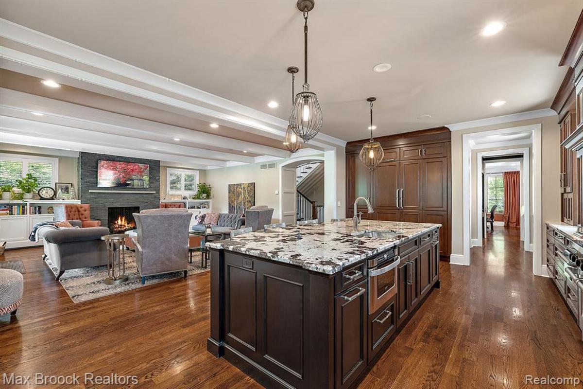 Kitchen with a large island, wood flooring and custom lights.