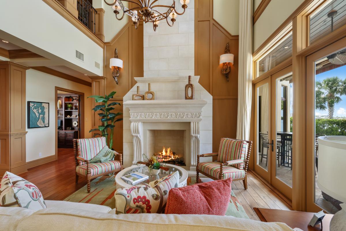 Living room with a couch, glass doors, fireplace and a large rug.
