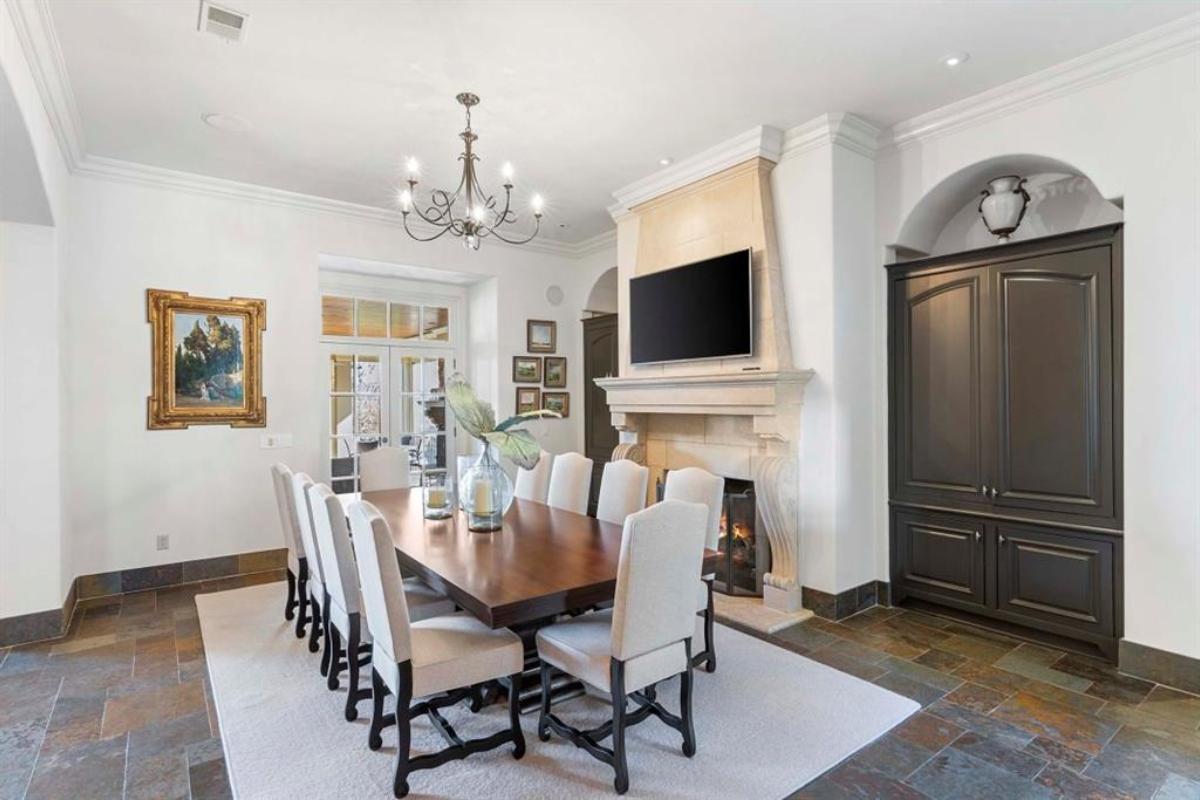 Dining room with a chandelier and a fireplace.