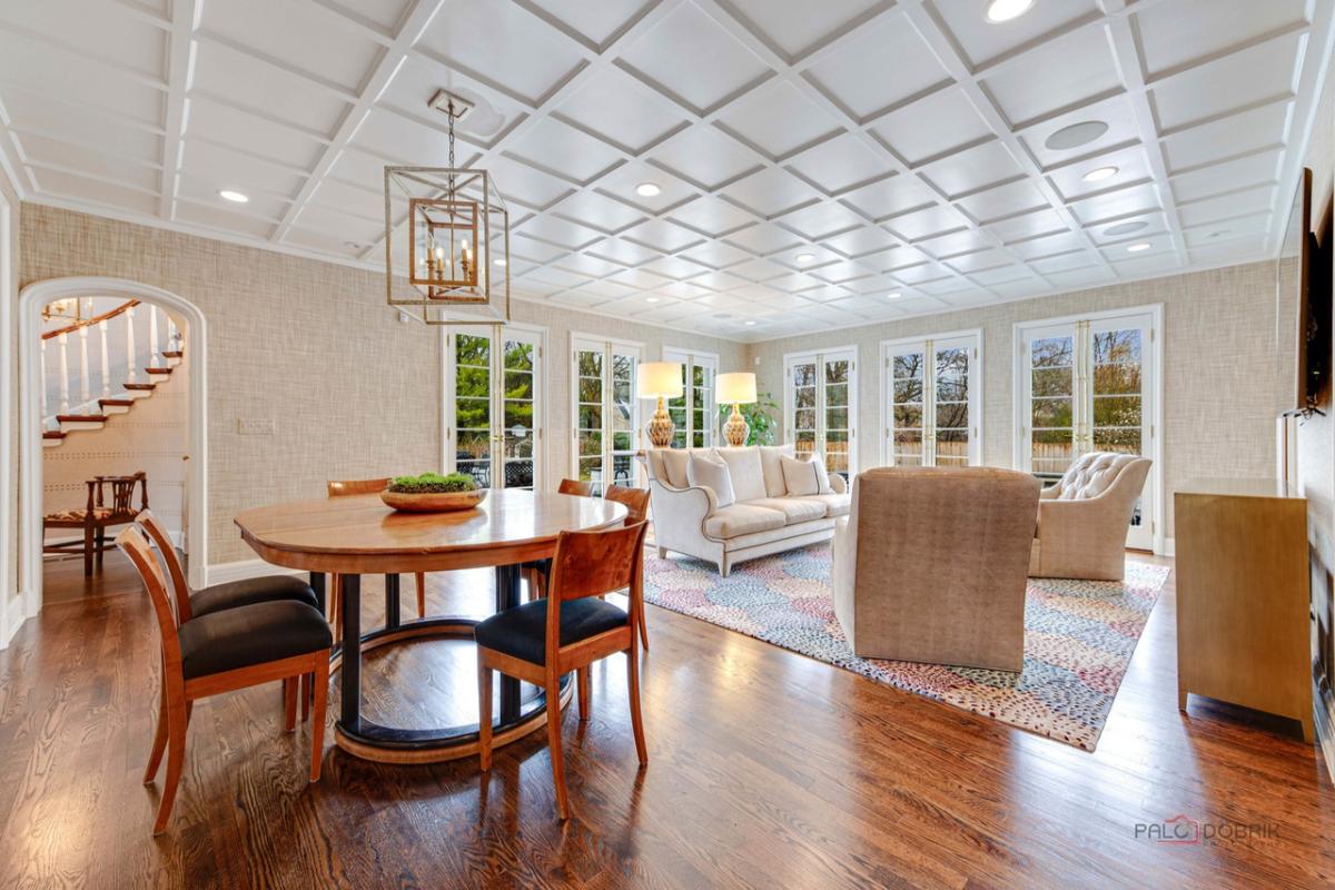 Breakfast nook with a round wooden table, chairs and a chandelier.