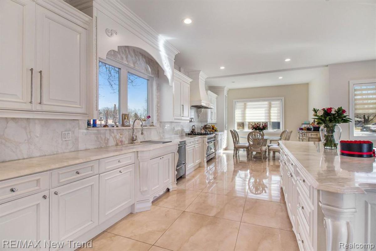 Kitchen with a large island, custom lights and custom cabinets.