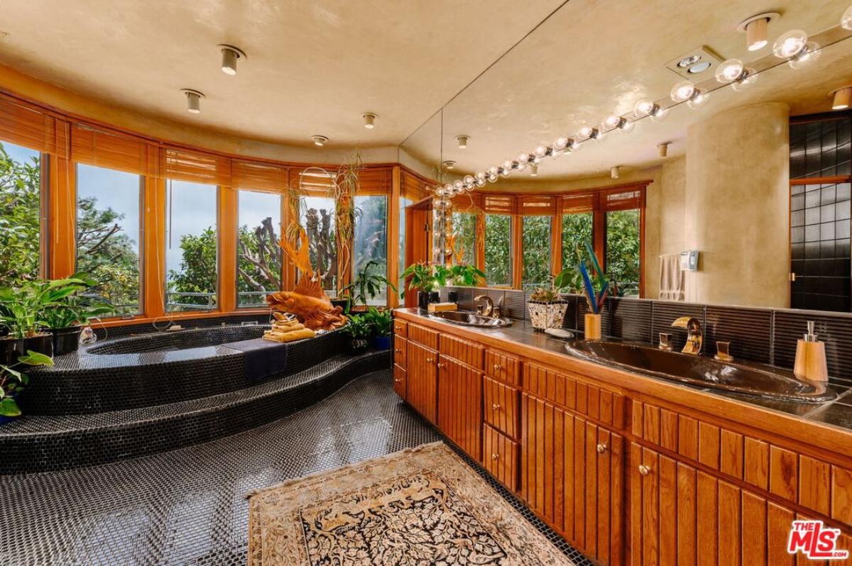 Bathroom with dual sinks, soaking tub, shower and glass windows.