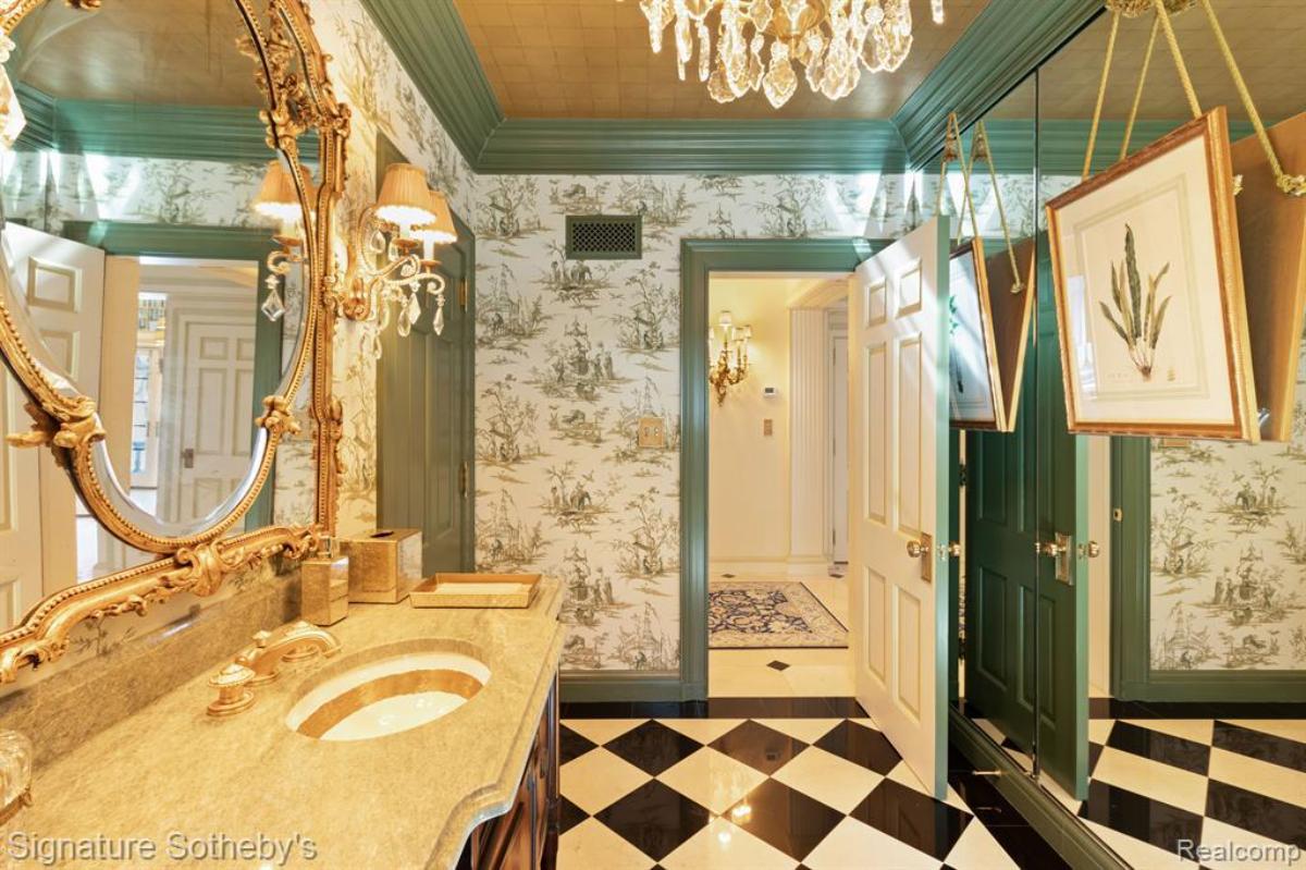 Bathroom with a sink, shower, mirror and a chandelier.