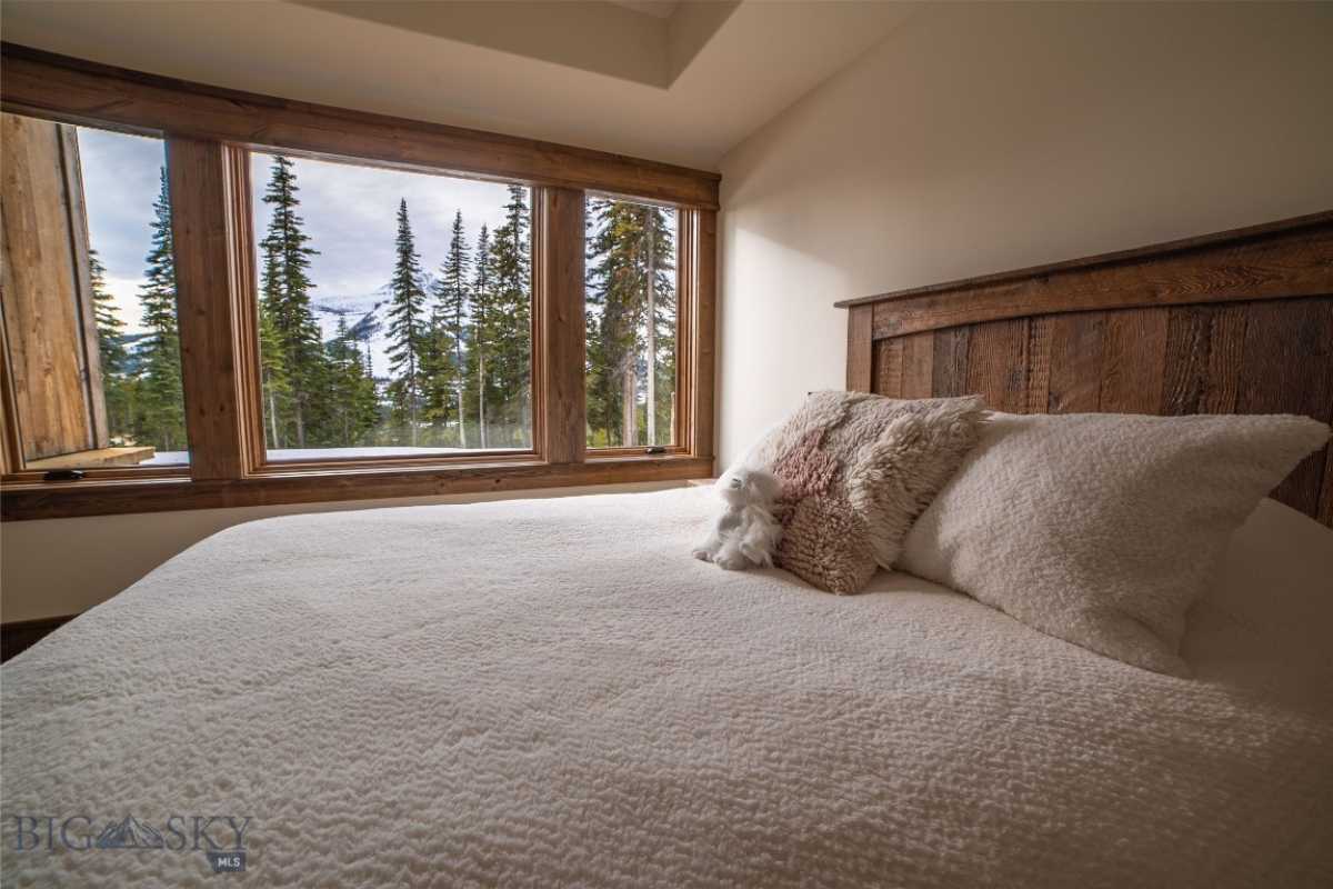 A bedroom with a large white bed and windows.