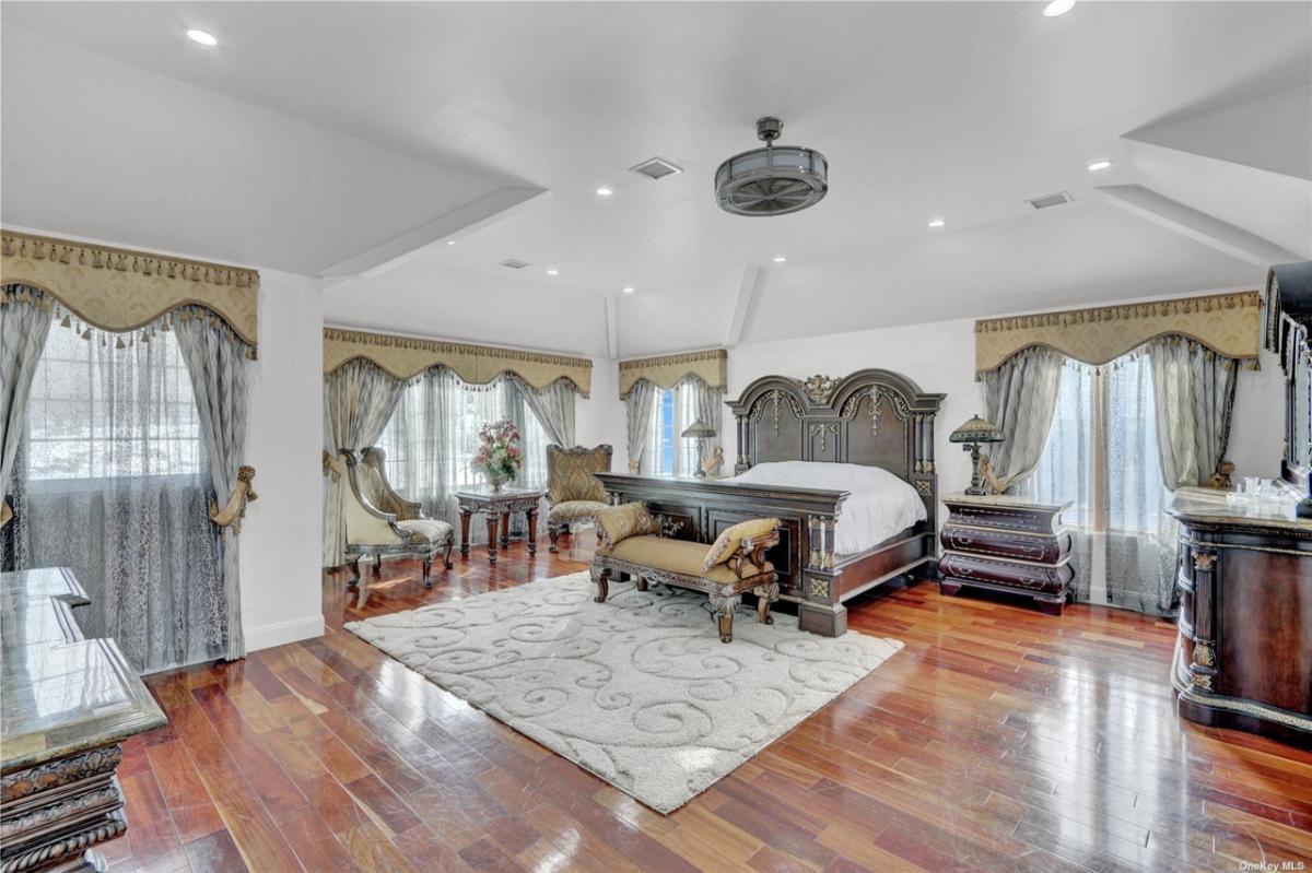 Bedroom with wood flooring and custom lighting.