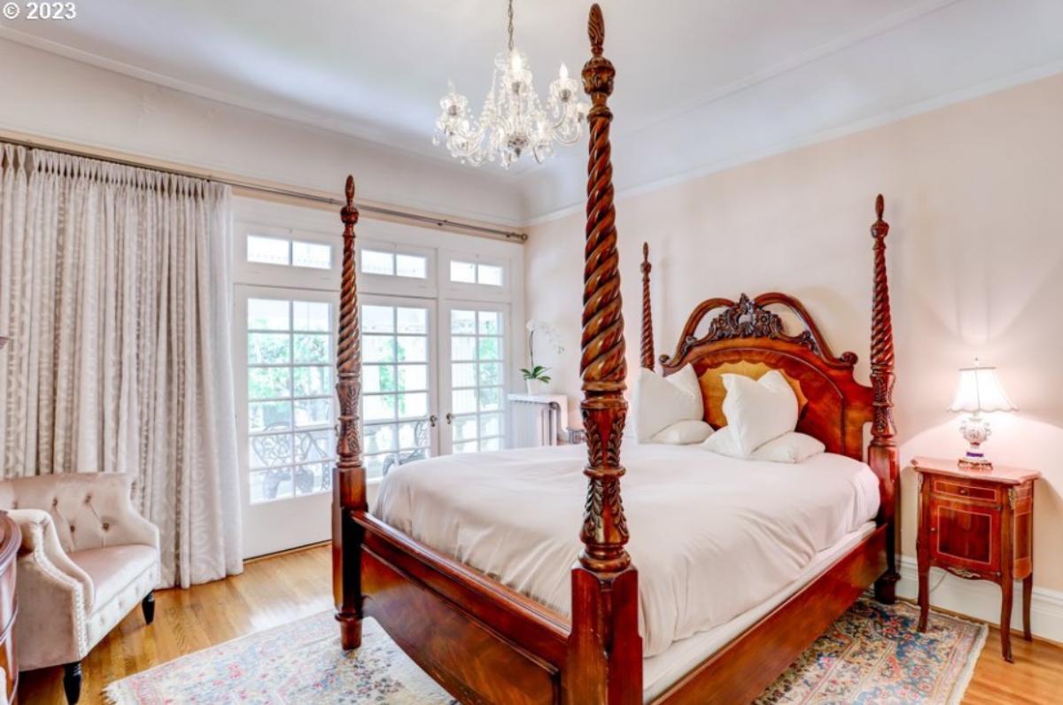 Bedroom with a chandelier, a large bed and a large rug.