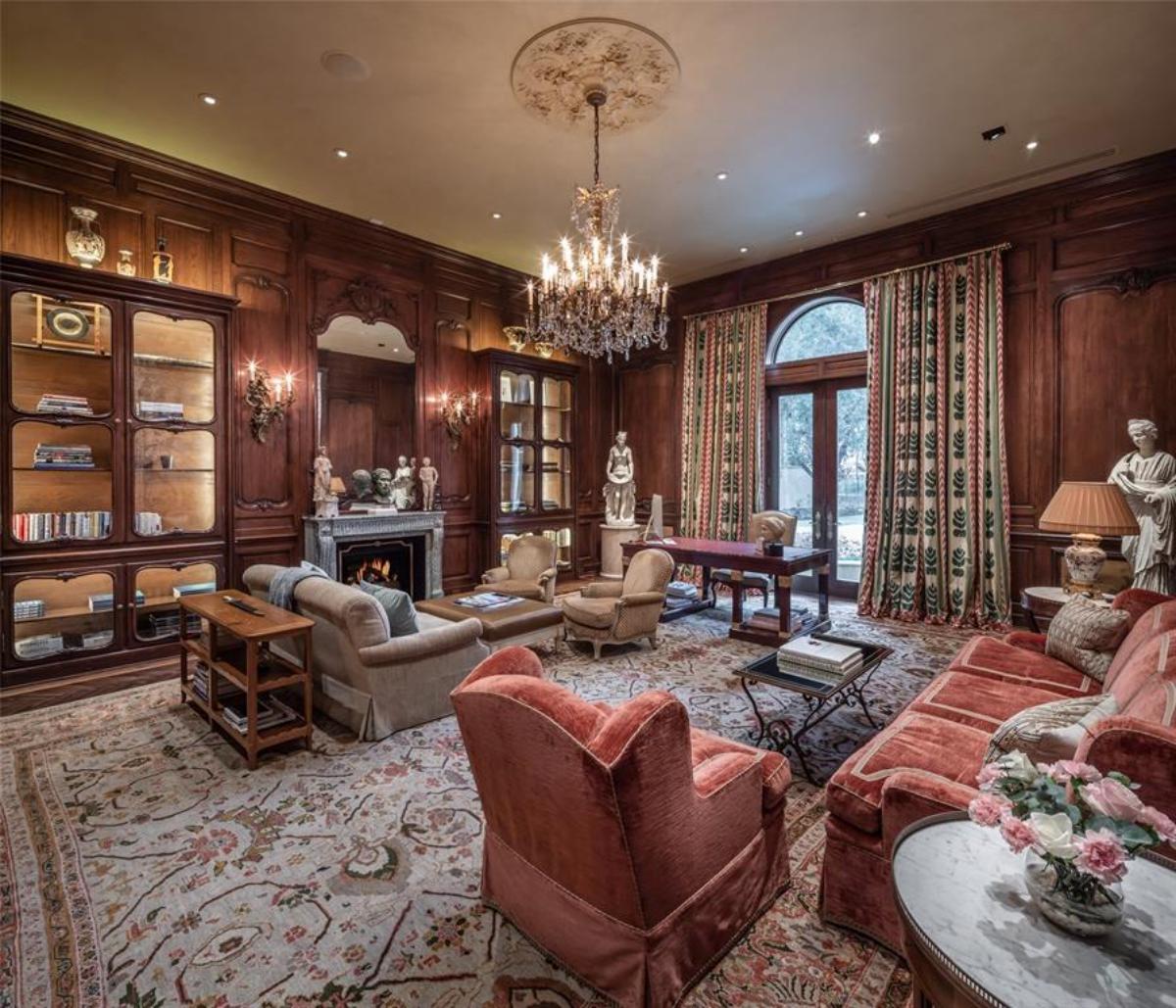 Home office with a desk, computer, couches, chandelier and custom lights.