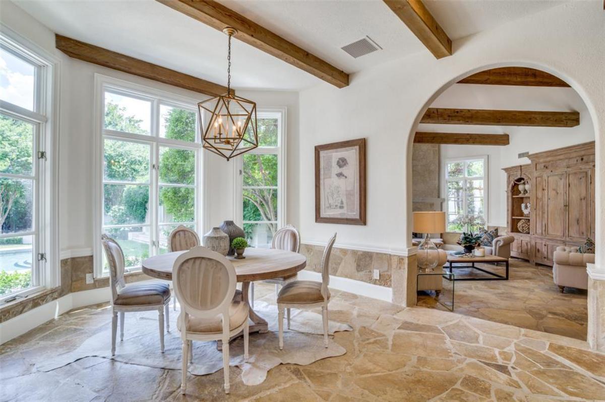 Breakfast nook with glass windows and open beam ceiling.