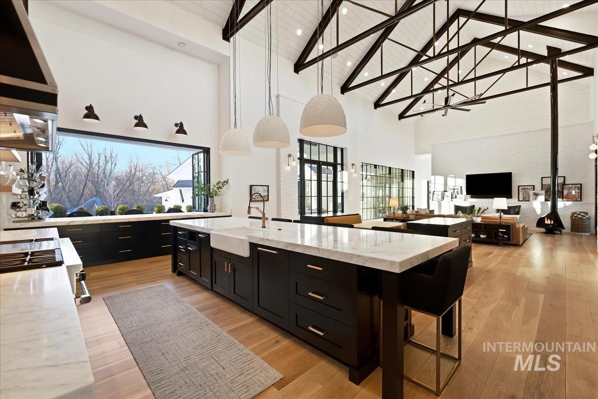 Kitchen with a large island, wood flooring and custom lights.