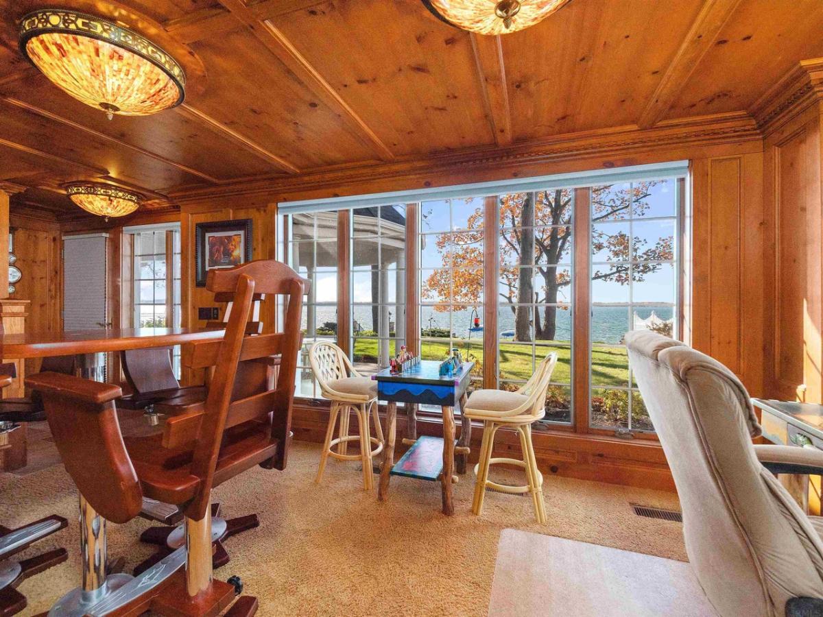 Entertainment room with glass windows, wooden ceiling and carpet flooring.