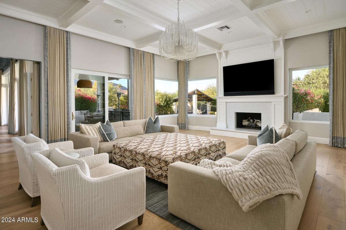 Living room with couches, TV and a fireplace.