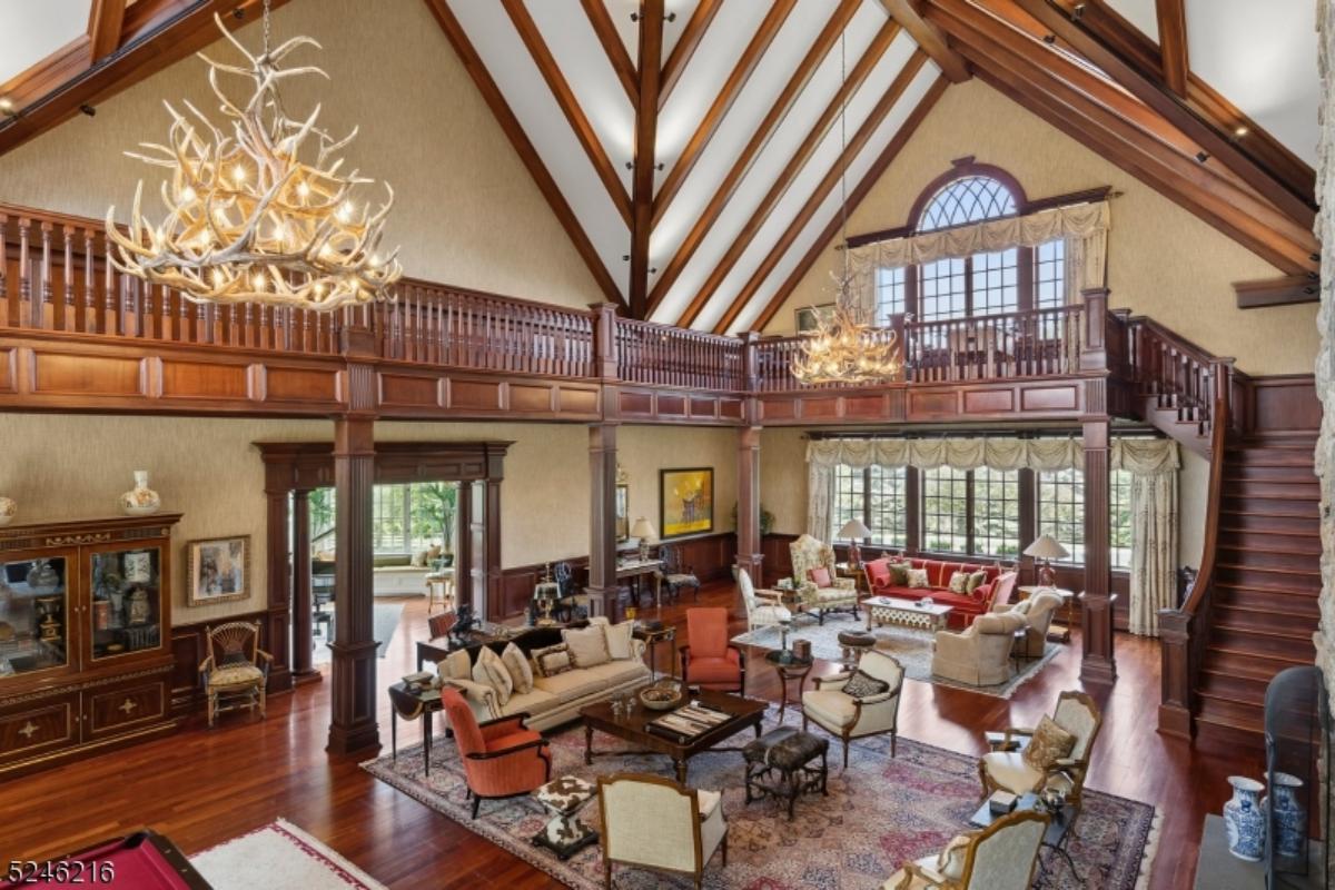 Living room with couches, chairs, glass windows and a wooden floor.