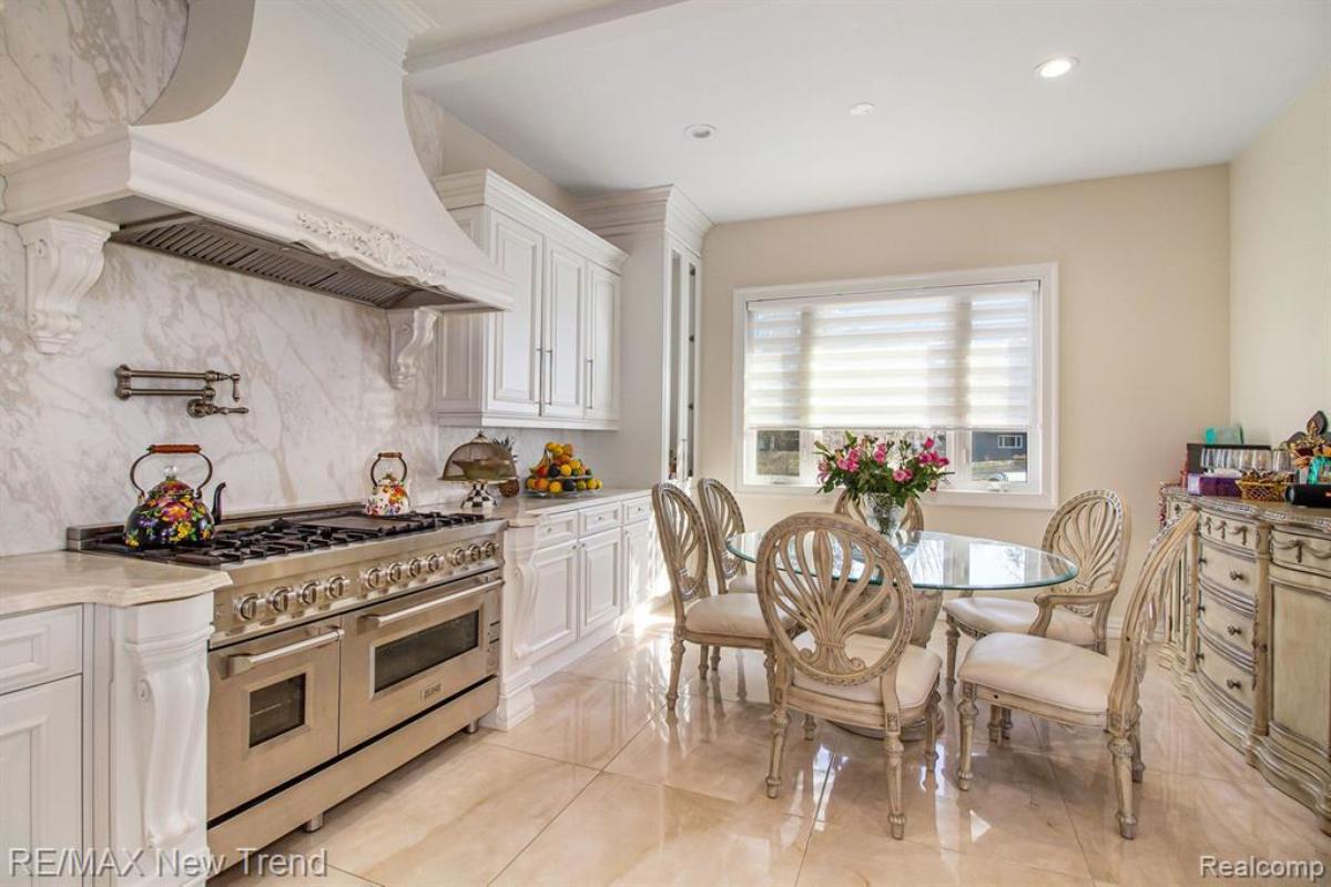 Dining room with a glass table, chairs and a stove. 