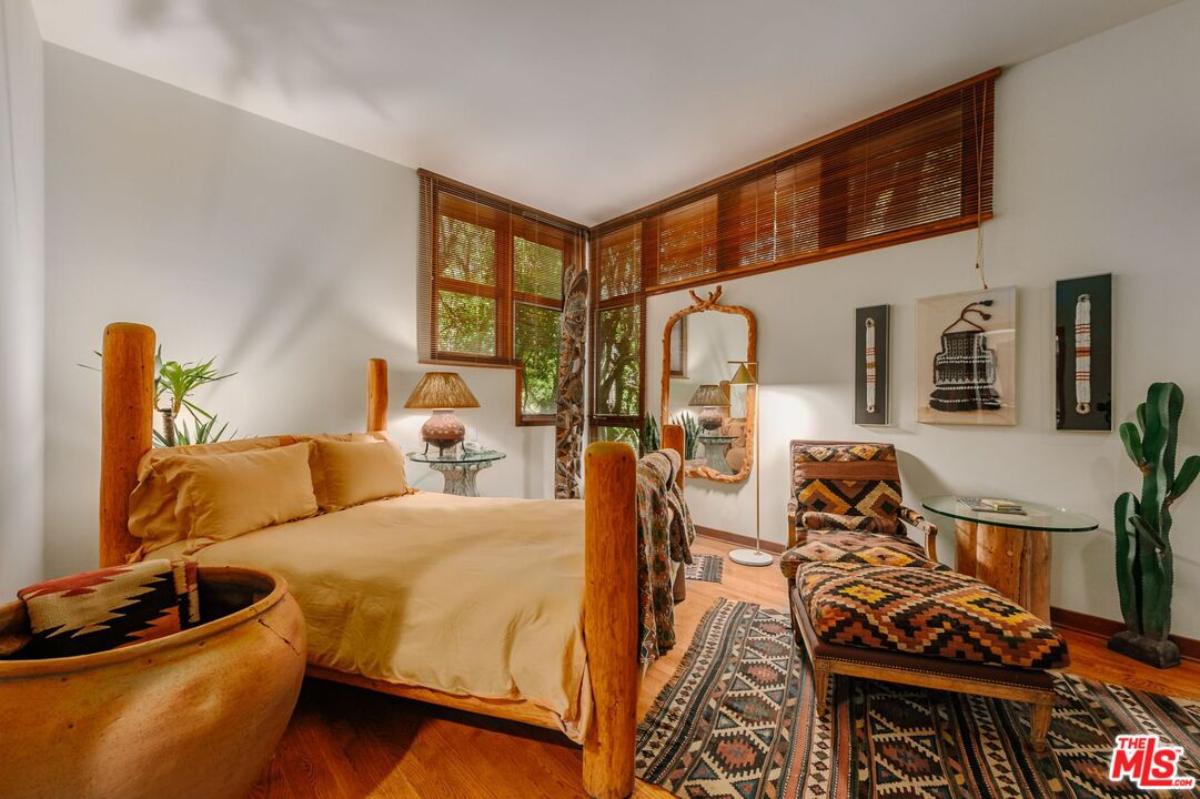 Bedroom with a large bed, wooden floor and a large rug.