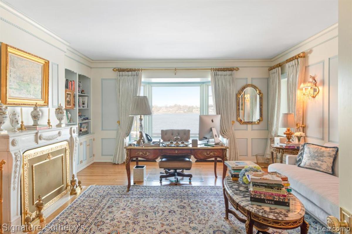 Home office with a desk, couch and a large rug.