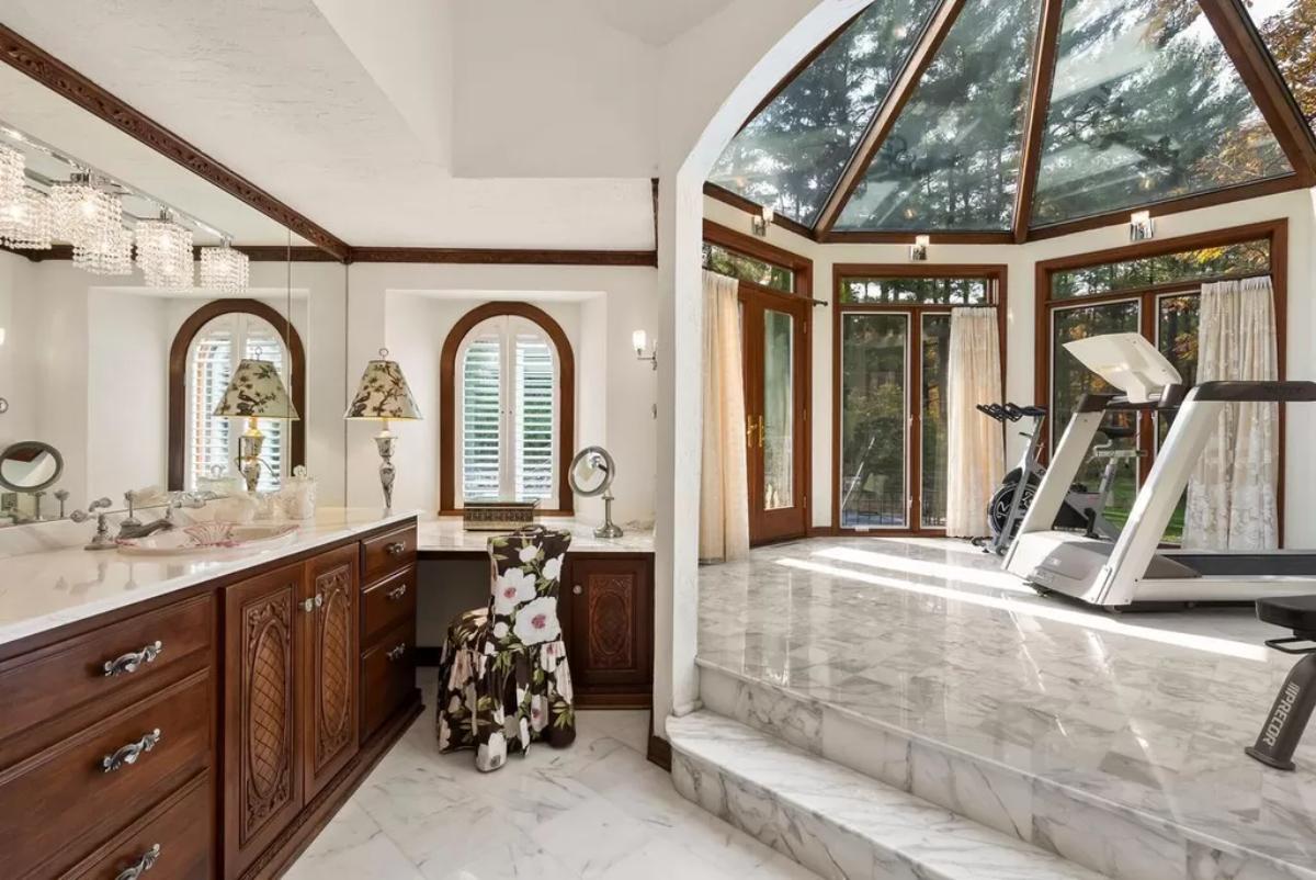 Home gym with tile flooring and skylight roofing.