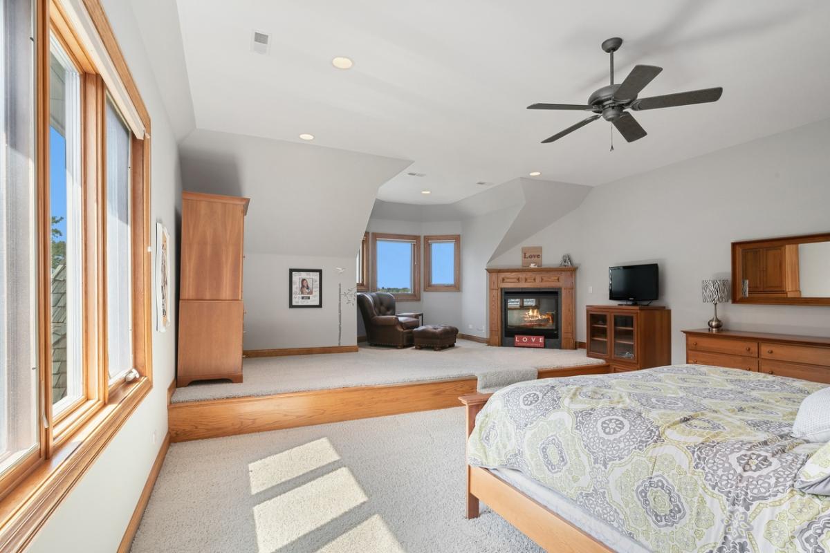 Bedroom with carpet flooring and a fireplace.