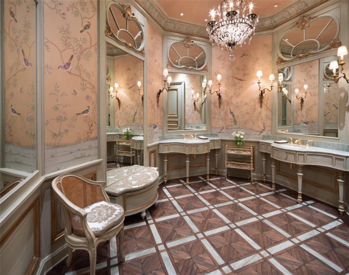 Bathroom with dual sinks, mirrors and a chandelier.