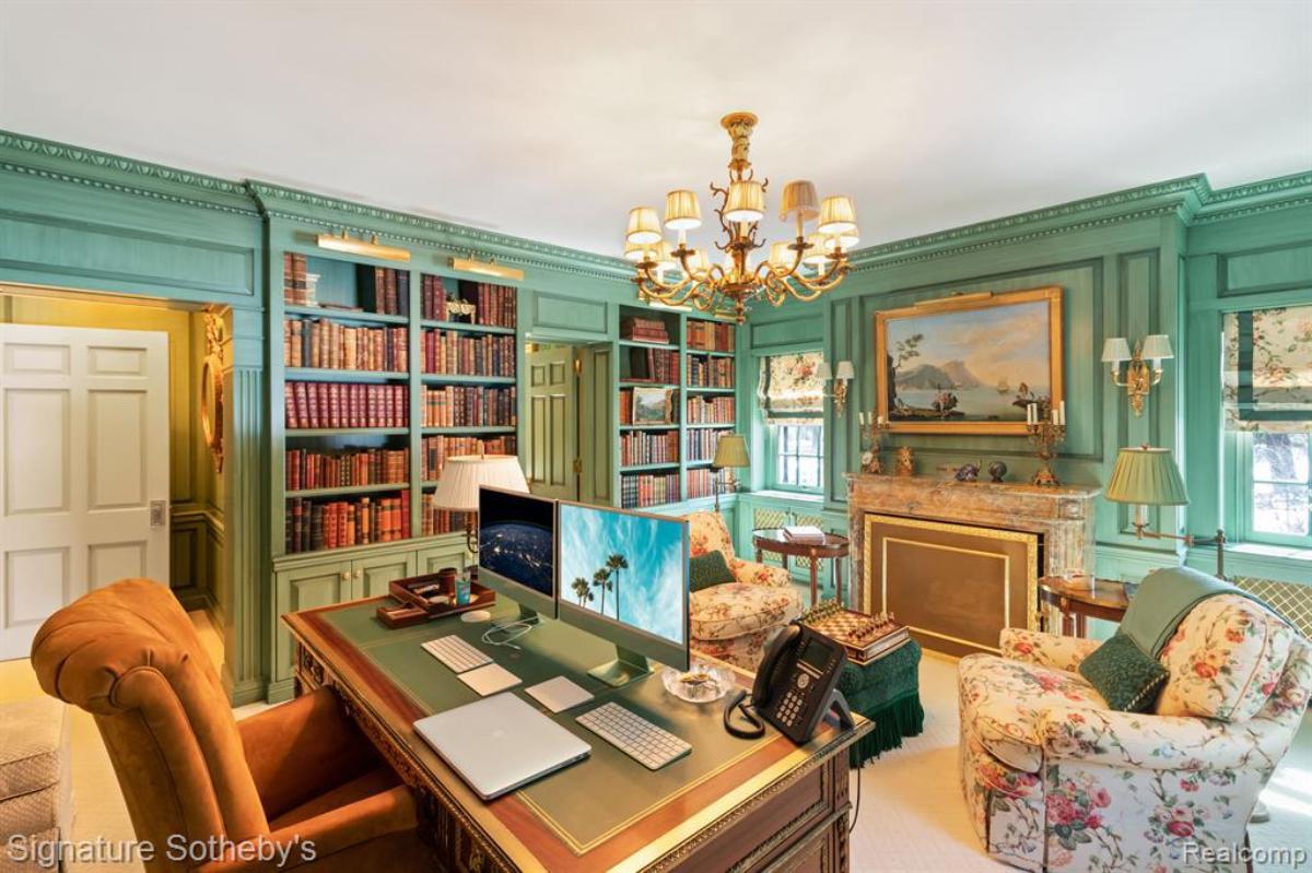 Home office with a desk, computer, chairs and bookshelves.