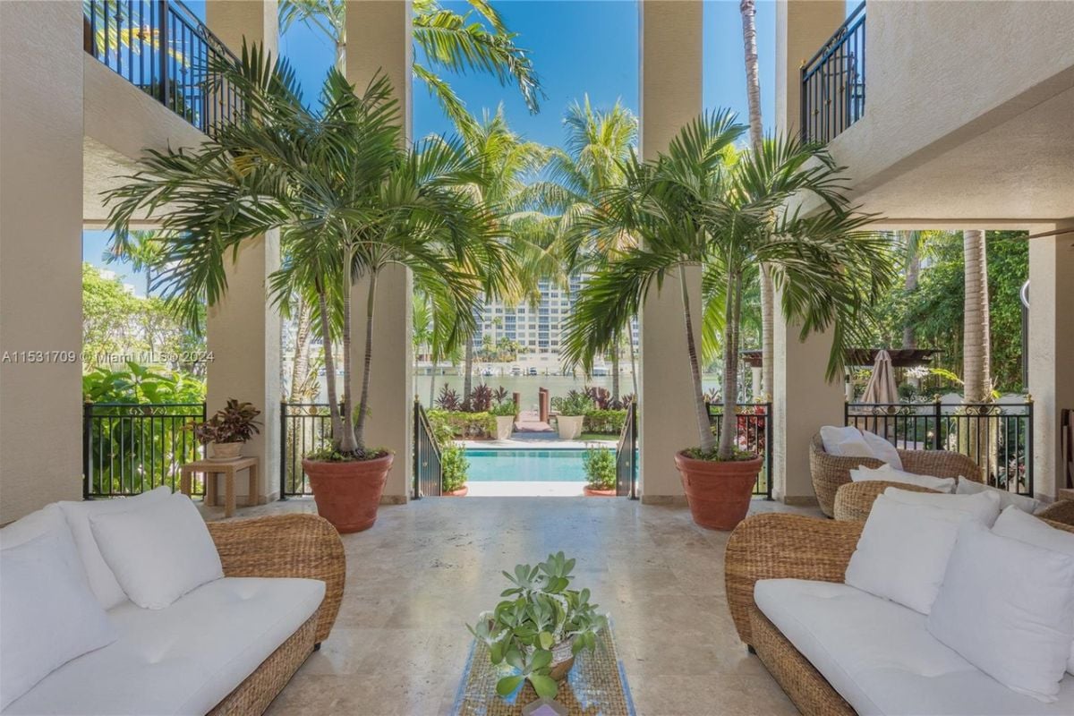 A patio furnished with couches, a center table, and adorned with plants.