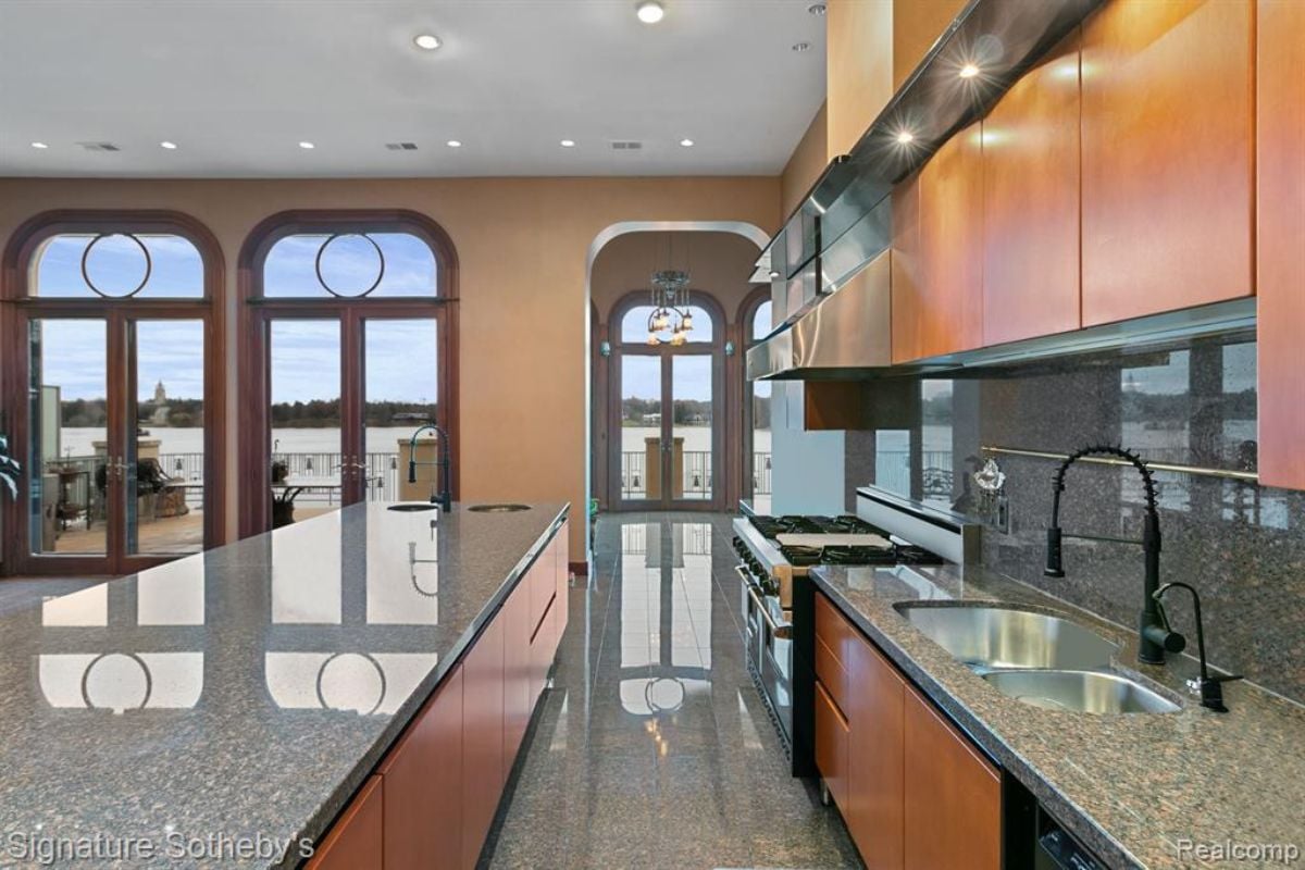 A kitchen with an island, a sink, wooden cabinets, and wooden cabinets.