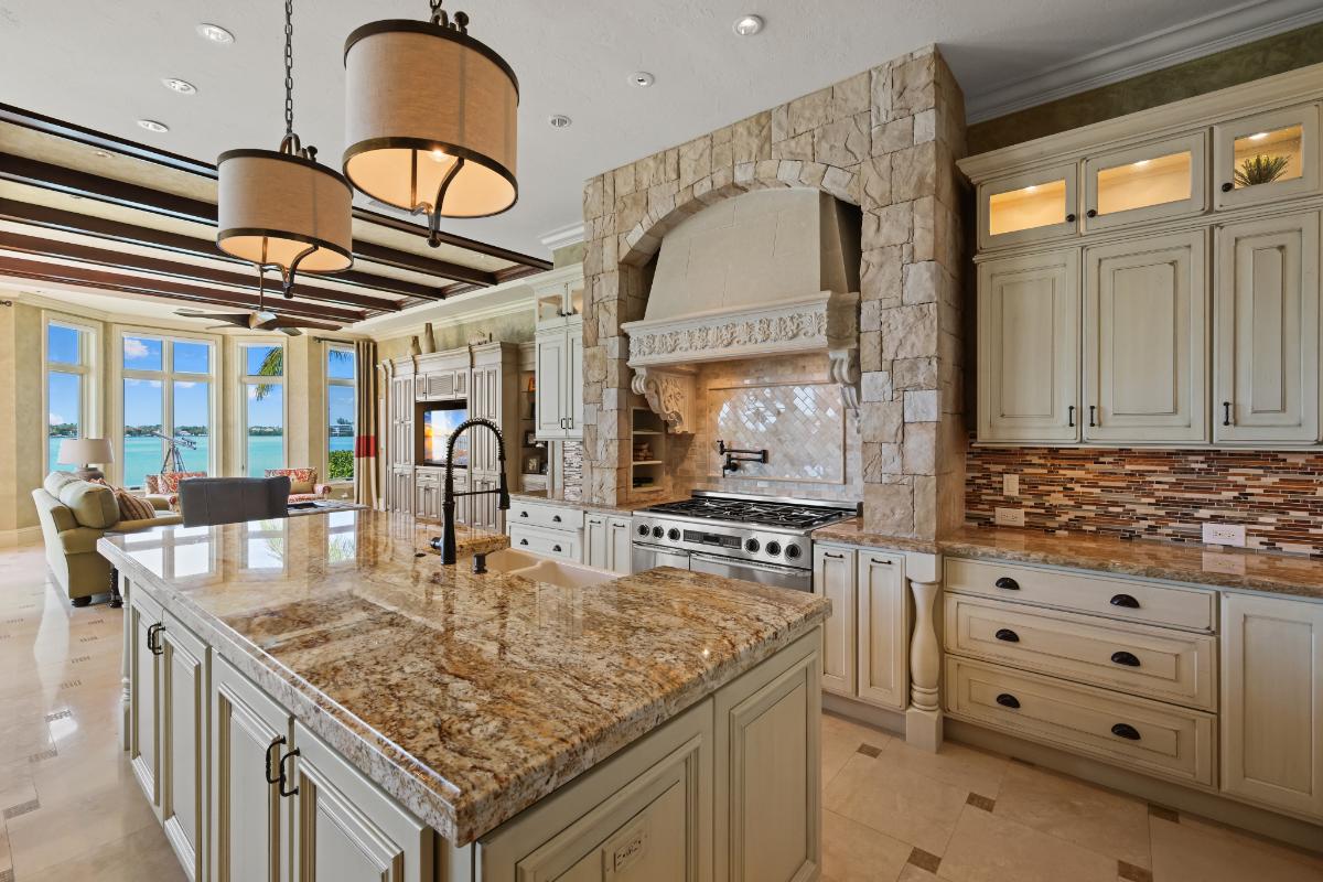 Kitchen with a large island, , stove and custom cabinets.