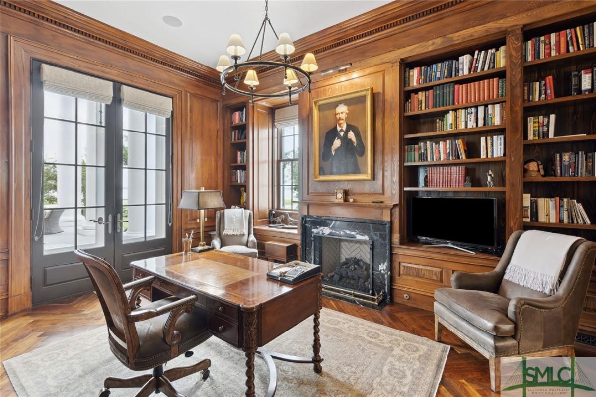 Home office with book shelves and a fireplace.