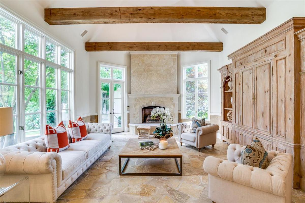 Living room with chairs, glass windows and a fireplace.