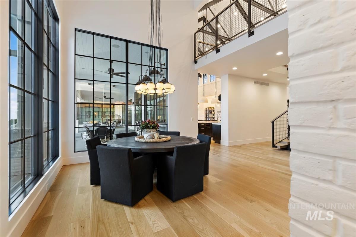 Dining room with a table, chairs, chandelier and a wood flooring.