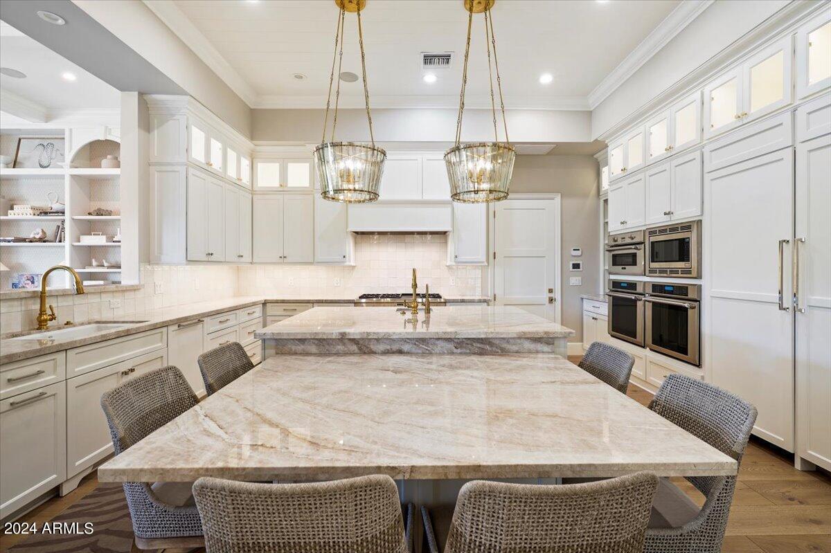 Kitchen with a large island, wood flooring and custom cabinets.