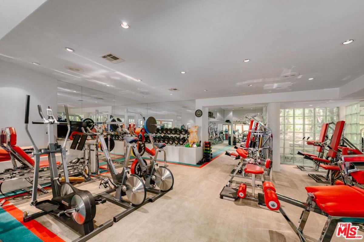Home gym with workout equipment, custom lights and glass walls.