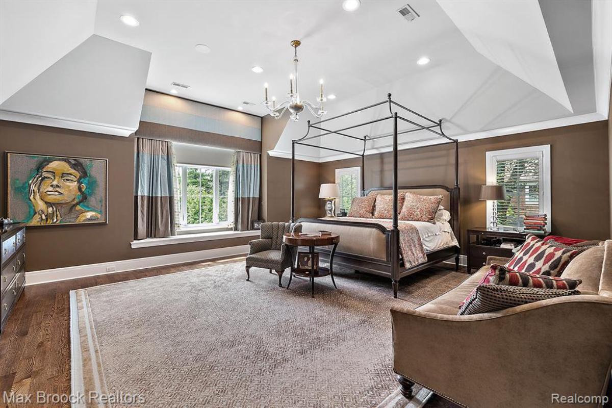 Bedroom with a large bed, large rug and large glass windows.