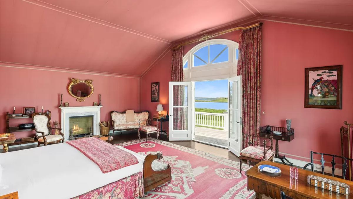 Bedroom with a large bed, glass doors and a large rug.
