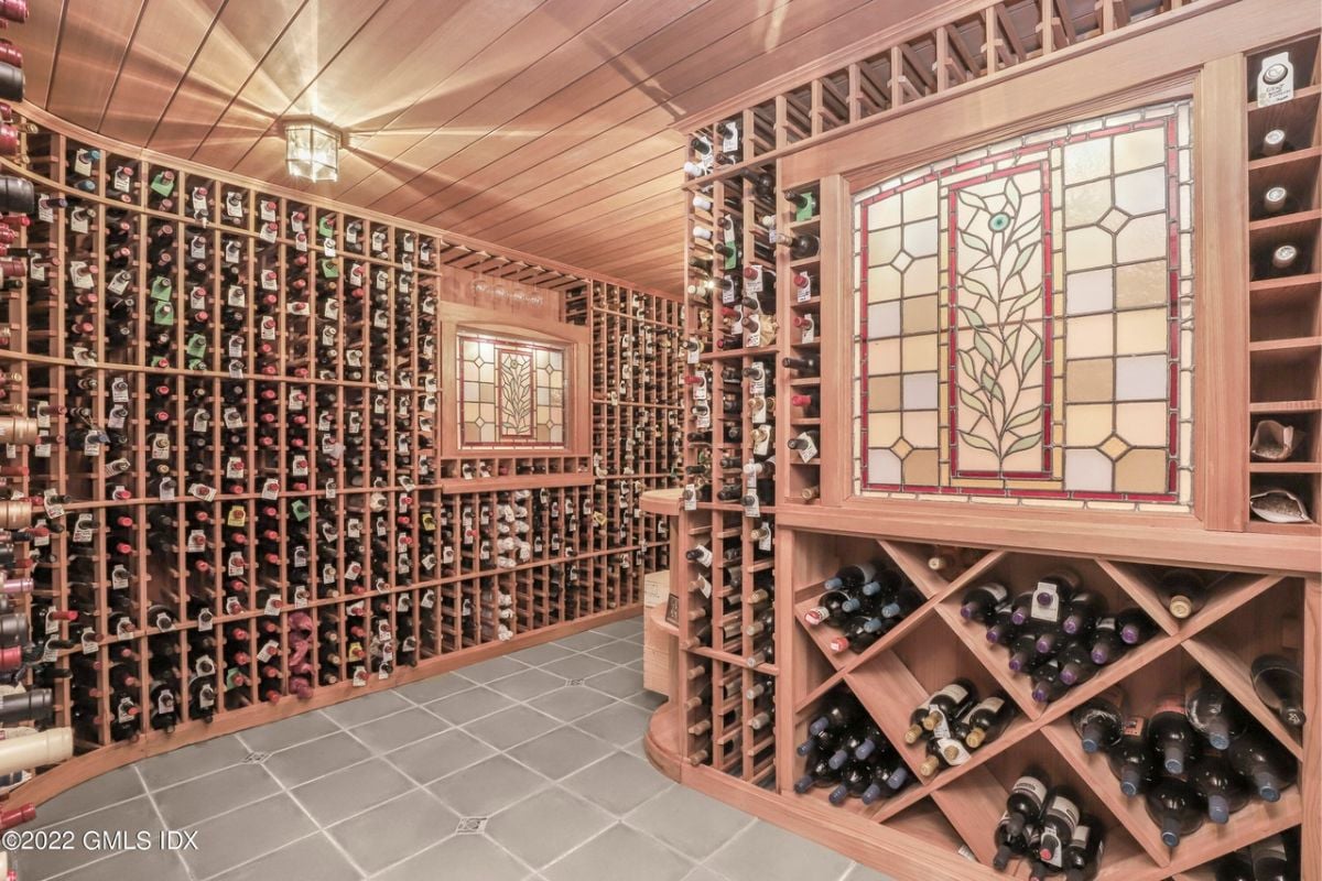 A wine cellar with a wooden ceiling and wine rack filled with wine bottles.