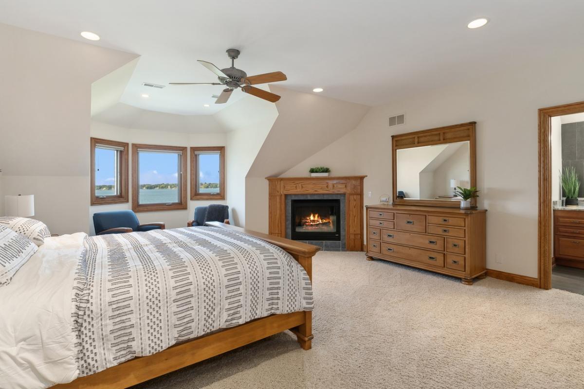 Bedroom with carpet flooring and a fireplace.