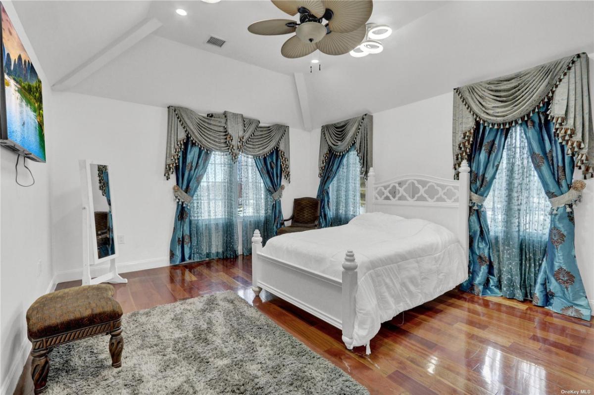 Bedroom with wood flooring and a large bed.