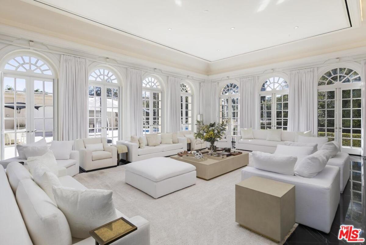 Living room with couches and glass windows.