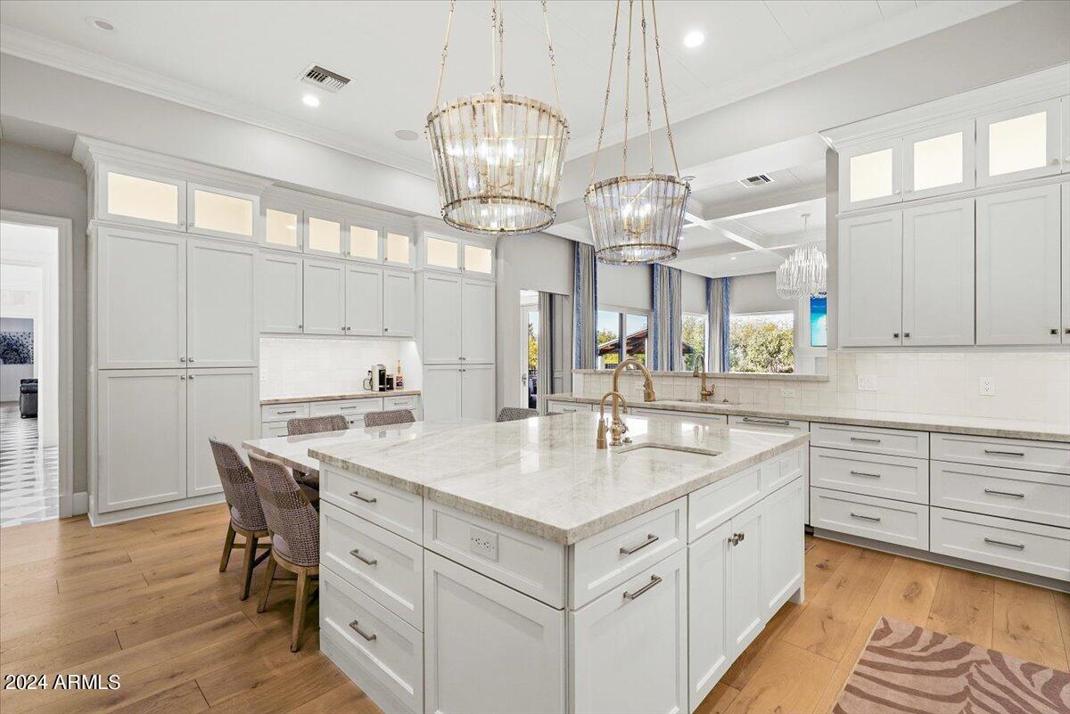 Kitchen with a large island, wood flooring and custom cabinets.