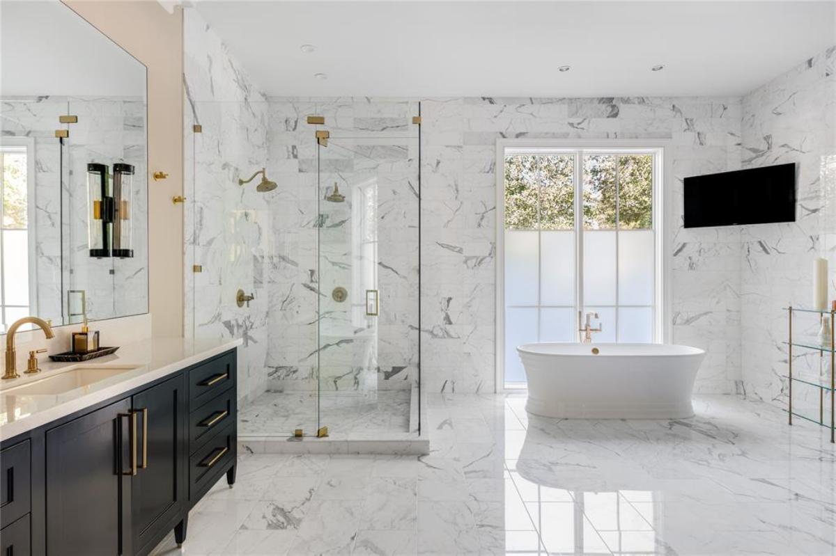 Bathroom with a soaking tub, sink, mirror and a walk-in shower.