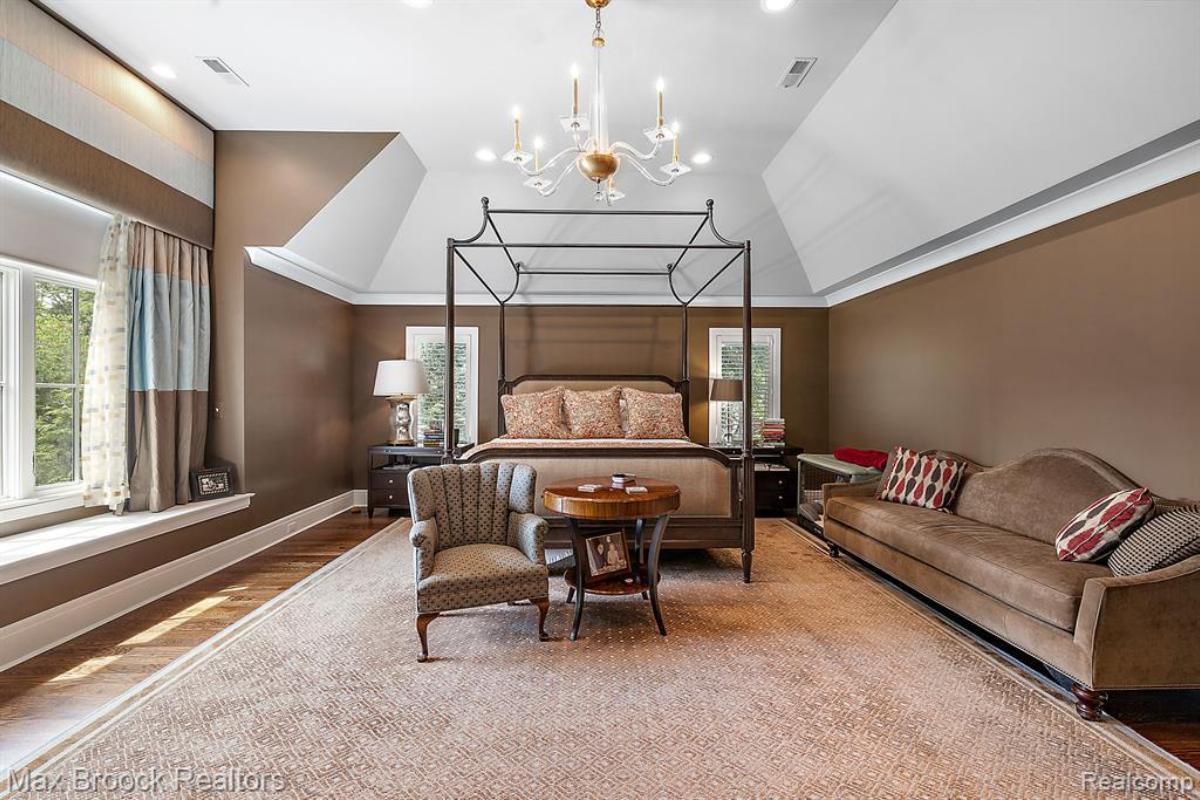 Bedroom with a large bed, large rug and large a couch.