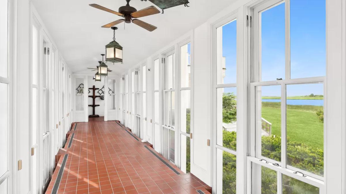 Hallway with ceiling fans and glass walls.