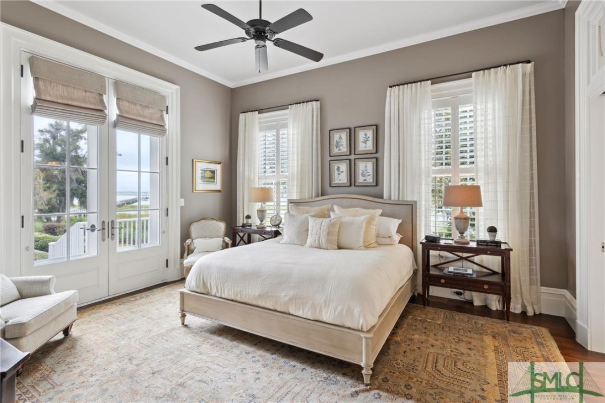 Bedroom with a large bed wood flooring and a large rug.