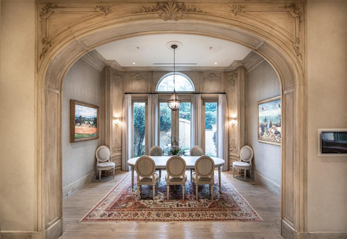 Dining room with a large table, chairs, glass doors and a large rug.