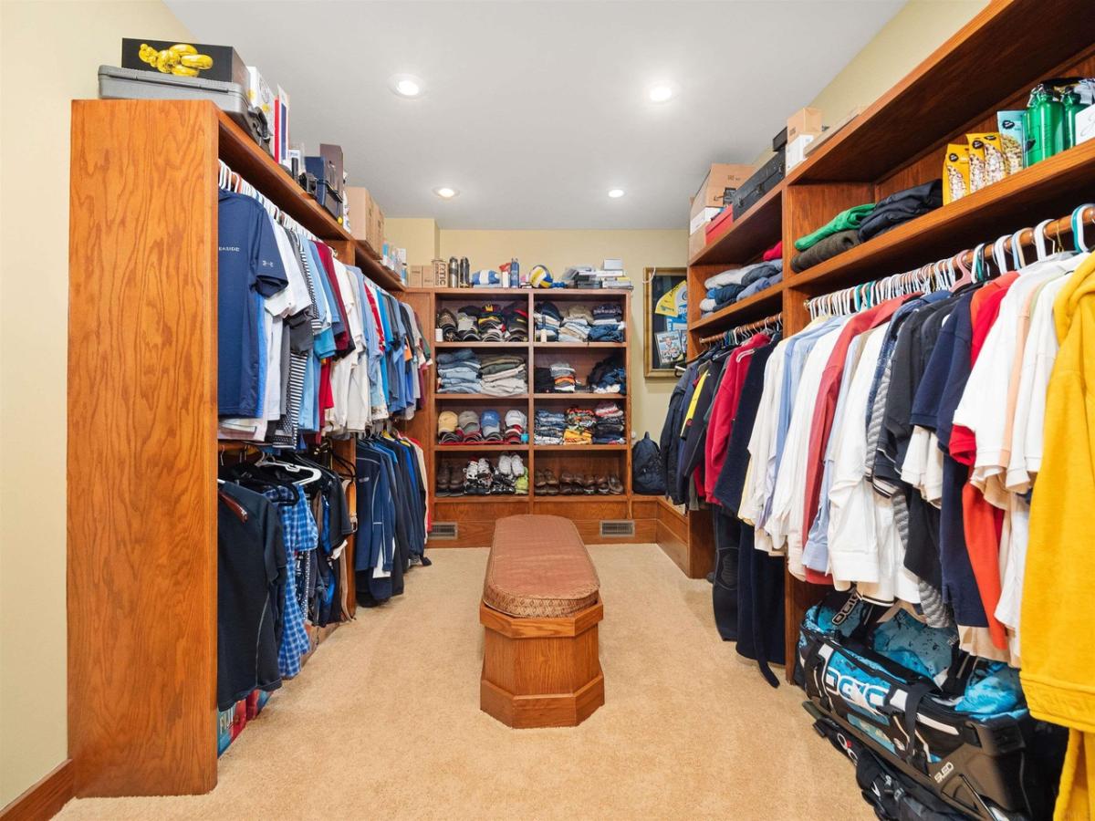 Walk-in closet with custom lights and a carpet flooring.
