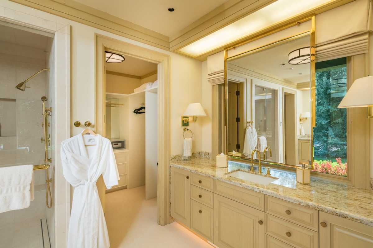 a bathroom with mirror, sink, wooden cabinets and shower room