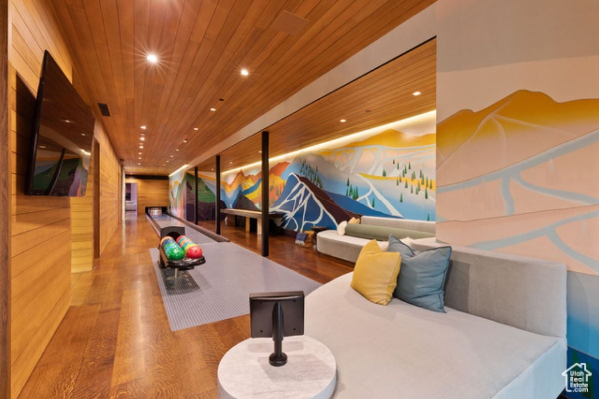 a game room with wooden floor, wooden ceiling, bowling facility and TV